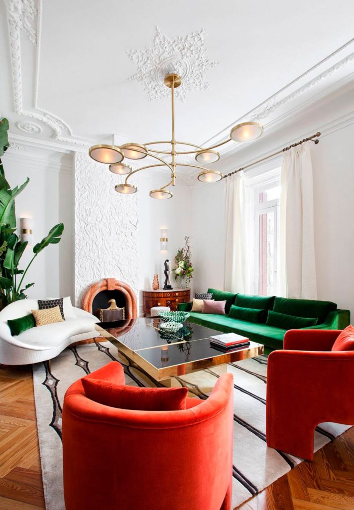 Salón blanco y crema con mueble color verde, butacas rojas, elementos decorativos en tonos amarillos