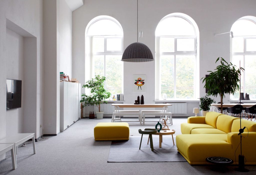Salón con sofá y puf en amarillo iluminado